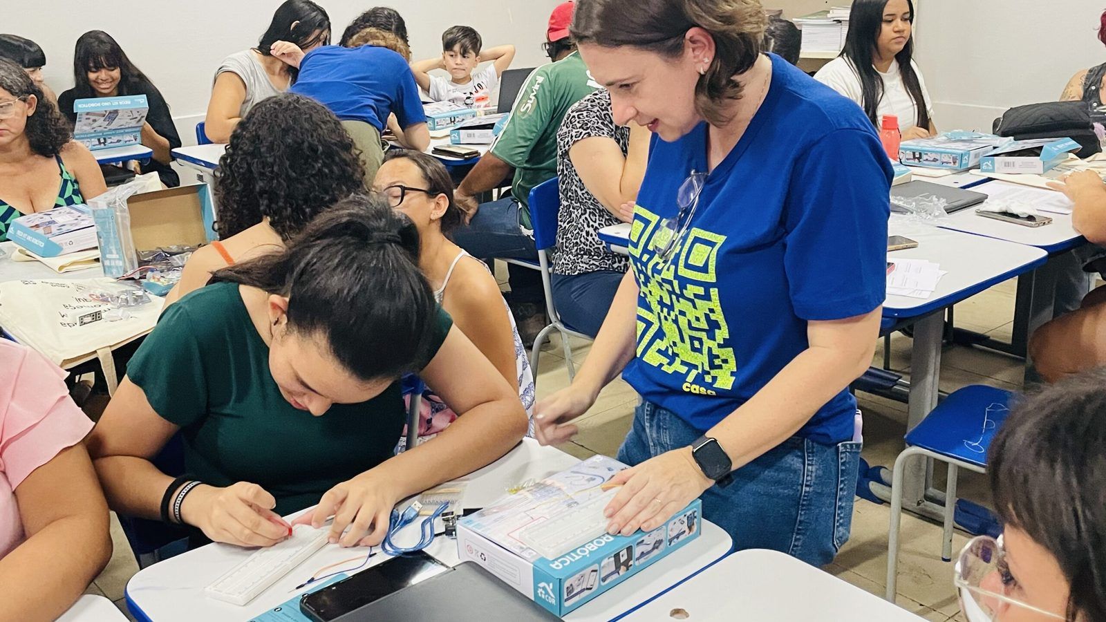Jovens em oficina de eletrônica da Casa Hacker, montando circuitos em grupo